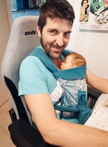 Μπαμπάς εργάζεται στον υπολογιστή φορώντας το μωράκι του σε μάρσιπο Αστεράκι mei tai