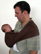 A dad and newborn making eye contact in an Asteraki carrier