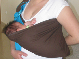 Newborn in the cradle position inside a sling