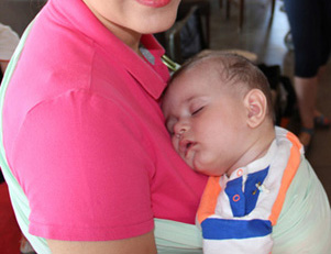 Tired baby sleeping in a sling