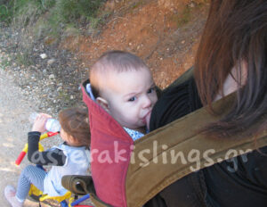 Baby breastfeeding in an Asteraki Mei Tai baby carrier