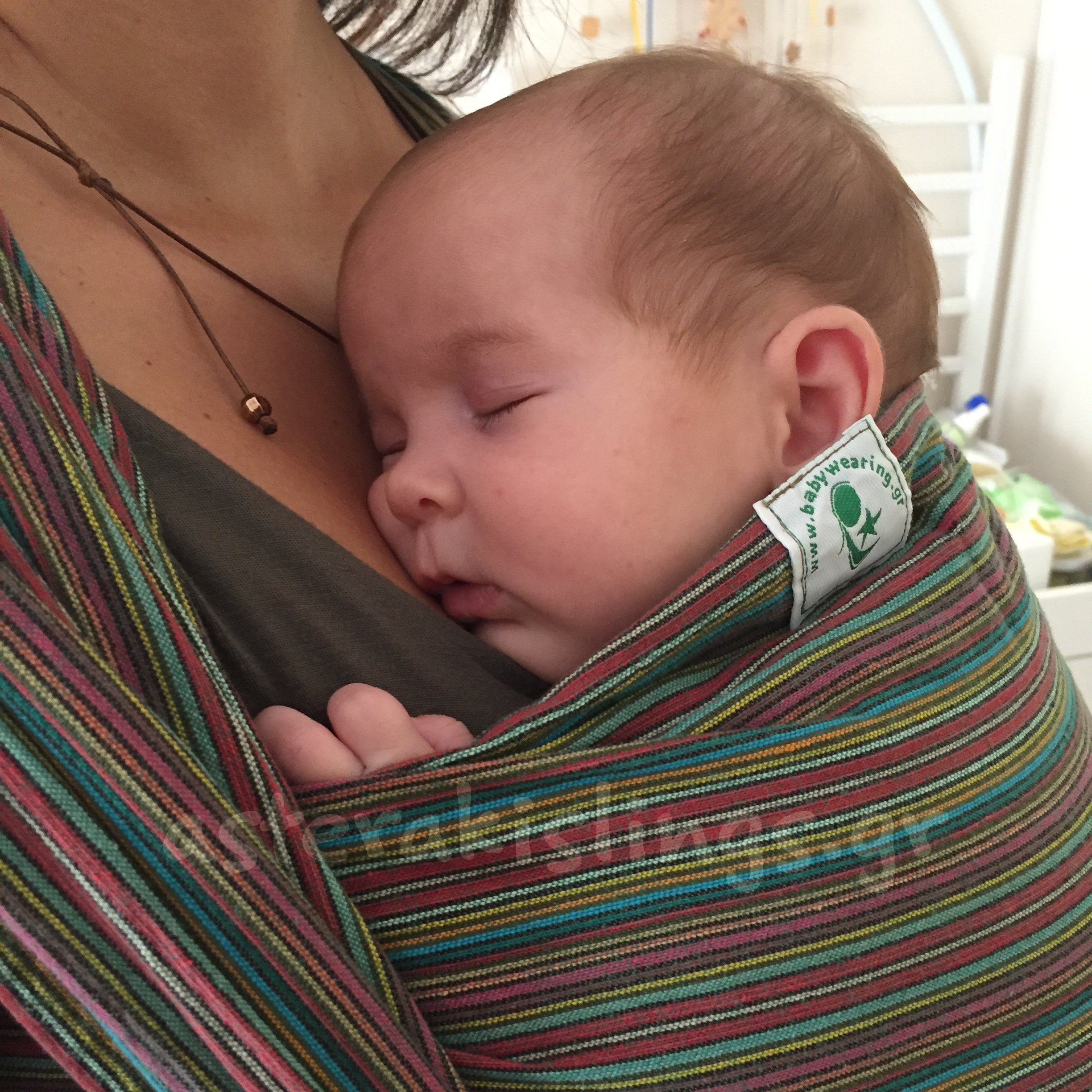 Newborn sleeping in a woven wrap