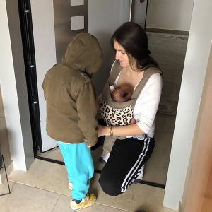 Μαμά με δύο παιδιά, φοράει το μωρό και βοηθάει το μεγαλύτερο αδερφάκι