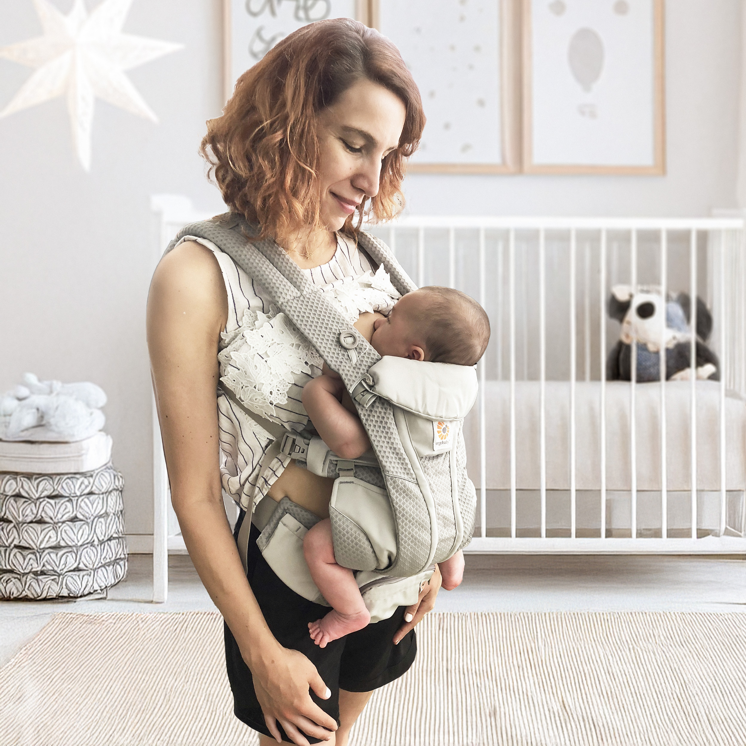 Mum breastfeeding her newborn in an Ergobaby Omni carrier